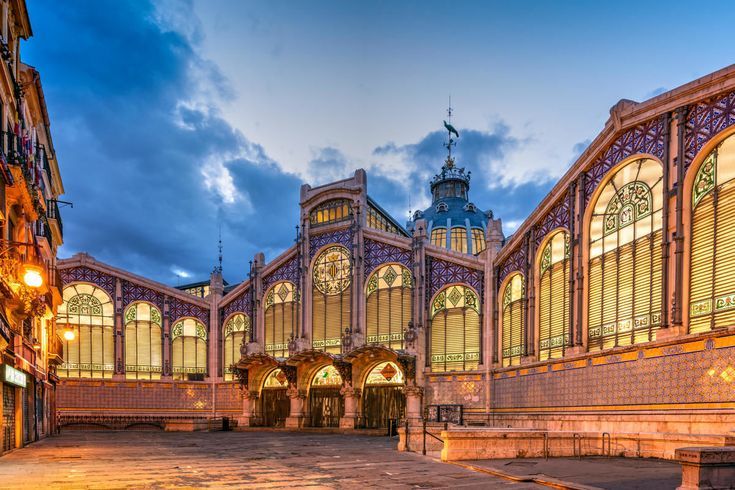 The modernist facade of the Mercado Central of Valencia lit at dusk
