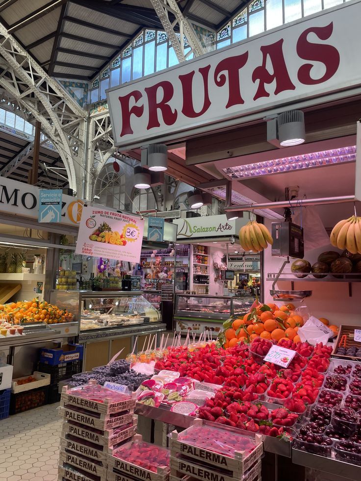 A fruit stall piled with strawberries and citrus inside the Mercado Central