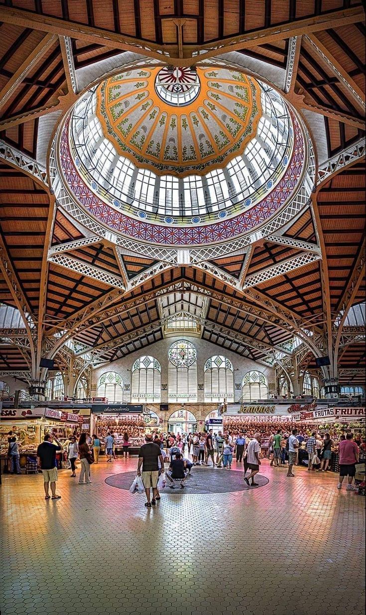 Inside the Mercado Central of Valencia, shoppers among the stalls under its modernist dome