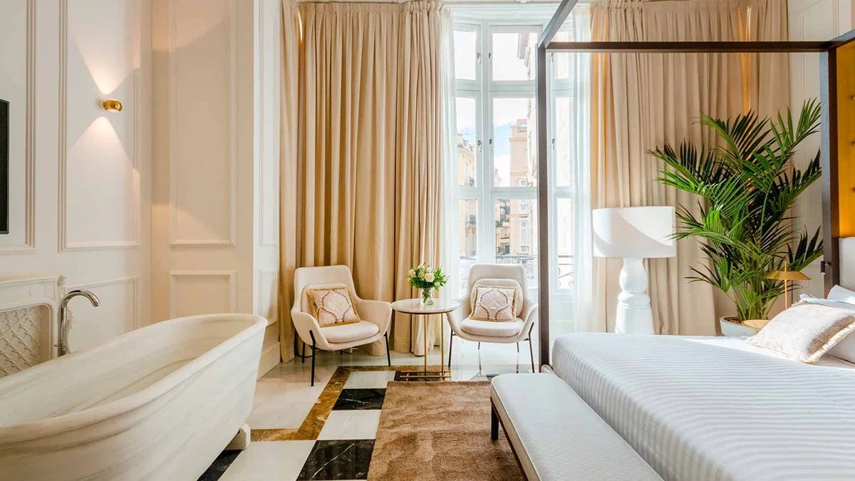 A light-filled suite with armchairs and tall windows at Palacio Vallier in Valencia
